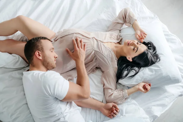 ハンサムな男抱擁妊娠中の女性でベッド — ストック写真