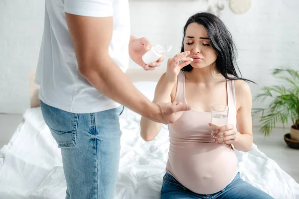 Man Ger Piller Till Vacker Gravid Fru Med Smärta Sovrummet — Stockfoto