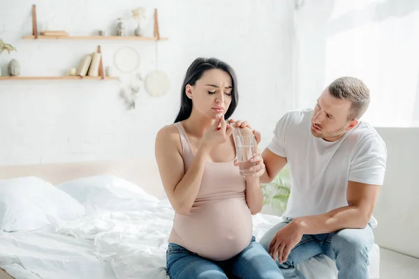 Atractiva Mujer Embarazada Con Dolor Tomar Píldora Con Agua Dormitorio —  Fotos de Stock