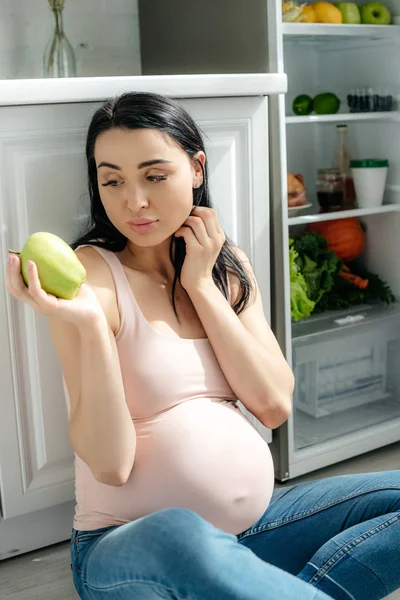 Beautiful Pregnant Woman Looking Apple While Sitting Floor Kitchen Opened — Stock Photo, Image