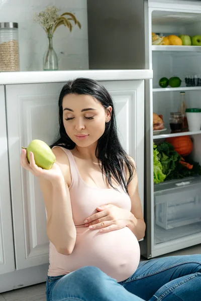 Happy Pregnant Woman Holding Apple While Sitting Floor Kitchen Opened — Stock Photo, Image
