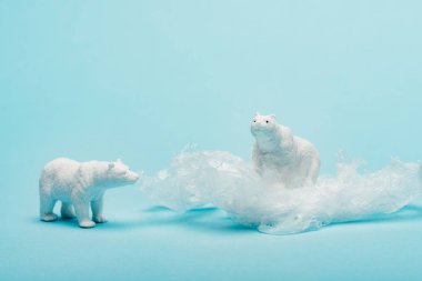 Mavi arka planda plastik paketli oyuncak kutup ayıları, hayvan refahı kavramı