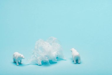 Mavi arka planda plastik paketli oyuncak kutup ayıları, hayvan refahı kavramı