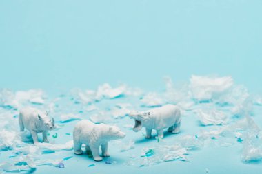 Beyaz su aygırı, gergedan ve ayının oyuncakları mavi arka planda plastik çöp, hayvan refahı konsepti