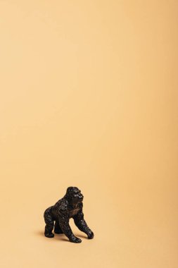 Black toy gorilla on yellow background, animal welfare concept clipart