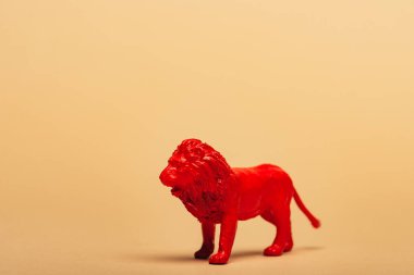 Red toy lion on yellow background, animal welfare concept clipart