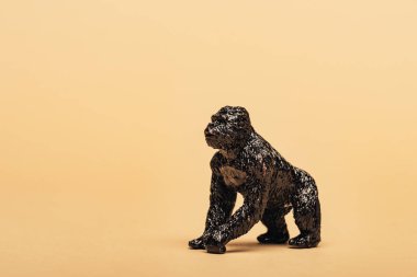 Black toy gorilla on yellow background, animal welfare concept clipart