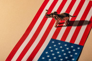 Golden toy elephant with shadow on american flag, animal welfare concept clipart