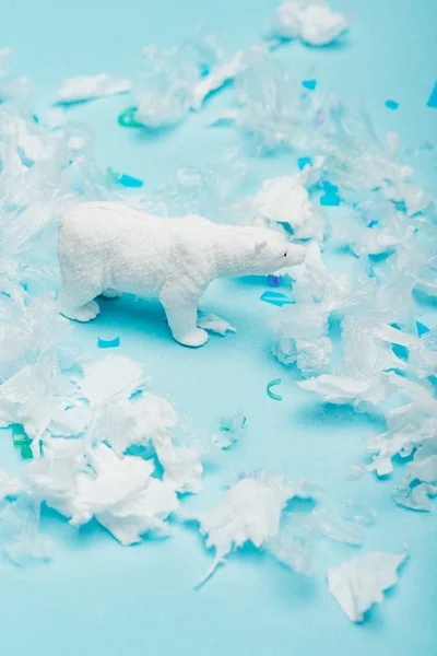 Mavi Arka Planda Polietilen Plastik Parçaları Olan Oyuncak Kutup Ayısı — Stok fotoğraf