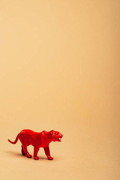 Красный игрушечный тигр на желтом фоне, концепция защиты животных
