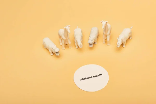 Sarı Arka Planda Plastiksiz Beyaz Oyuncak Hayvanlar Çevre Kirliliği Kavramı — Stok fotoğraf
