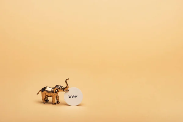 Elefante Juguete Dorado Con Letras Agua Tarjeta Sobre Fondo Amarillo — Foto de Stock