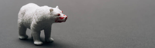 Panoramic shot of white toy bear with blood on grey background, killing animals concept