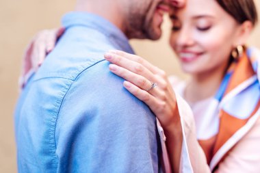 selective focus of young woman in wedding ring embracing boyfriend  clipart