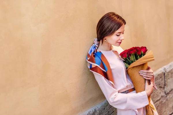 Menina Pensativo Segurando Buquê Rosas Vermelhas Enquanto Está Perto Parede — Fotografia de Stock