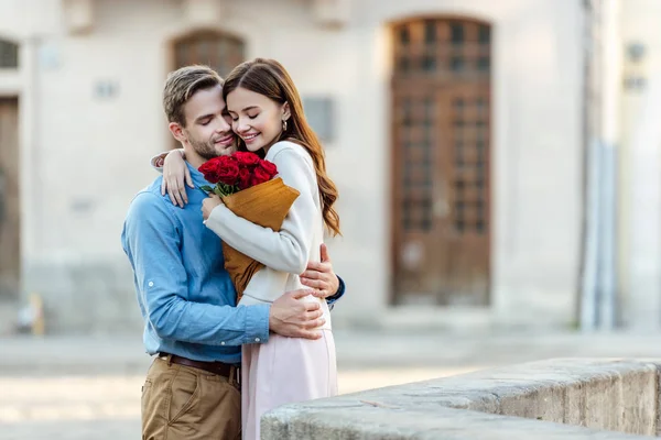 Happy Girl Embracing Boyfriend While Holding Bouquet Roses Street — Stock Photo, Image