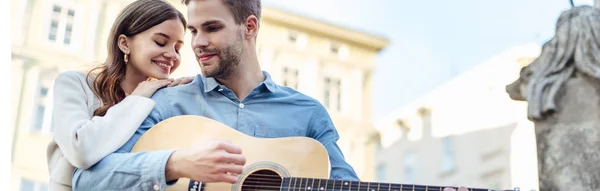 Tiro Panorâmico Menina Feliz Apoiando Ombro Namorado Tocando Guitarra Acústica — Fotografia de Stock