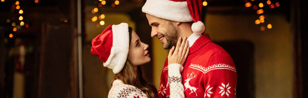 вид сбоку счастливой девушки, трогающей лицо улыбающегося бойфренда, панорамный снимок
 