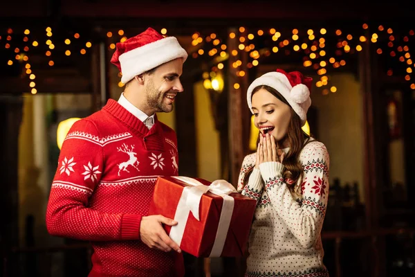 Smiling Man Presenting Christmas Gift Amazed Girlfriend — Stock Photo, Image