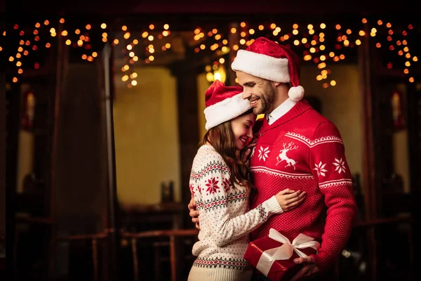 Glückliches Paar Warmen Pullovern Und Weihnachtsmützen Das Sich Auf Der — Stockfoto