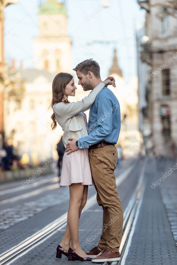 side view of happy young tourists embracing on street