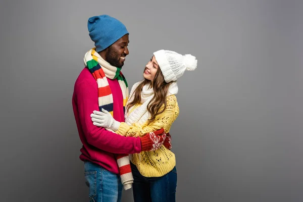 Sorrindo Casal Interracial Roupa Inverno Abraçando Fundo Cinza — Fotografia de Stock