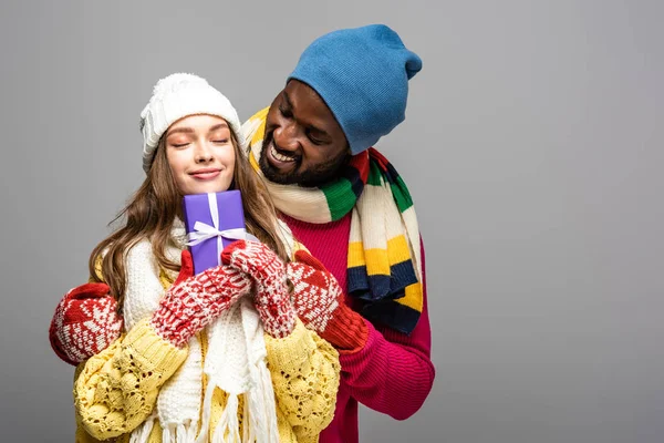 Feliz Casal Interracial Inverno Roupa Segurando Presente Isolado Cinza — Fotografia de Stock