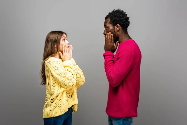 Shocked Interracial Couple Knitted Sweaters Looking Each Other Grey Background — Stock Photo, Image