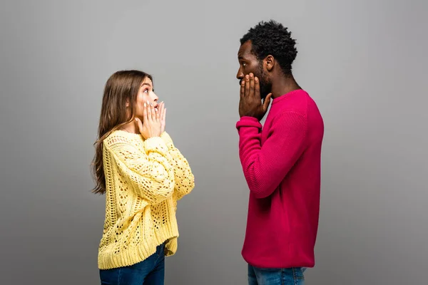 Impactado Interracial Pareja Punto Suéteres Mirando Uno Otro Gris Fondo — Foto de Stock