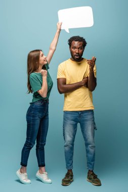 Konuşma balonunu Afrika kökenli Amerikalı adamın üzerinde tutan kız mavi arka planda fikir jesti yapıyor.