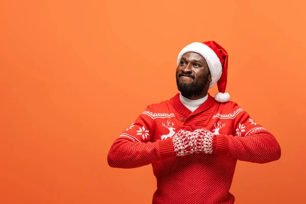 Boze Afro Amerikaanse Man Met Kerstmuts Wanten Kersttrui Oranje Achtergrond — Stockfoto