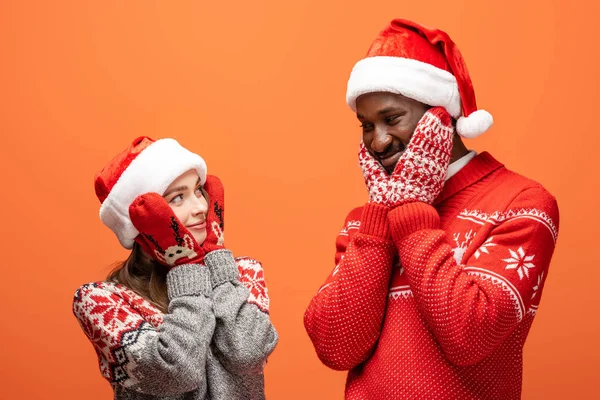 Happy Interracial Couple Santa Hats Mittens Christmas Sweaters Touching Cheeks — Stock Photo, Image