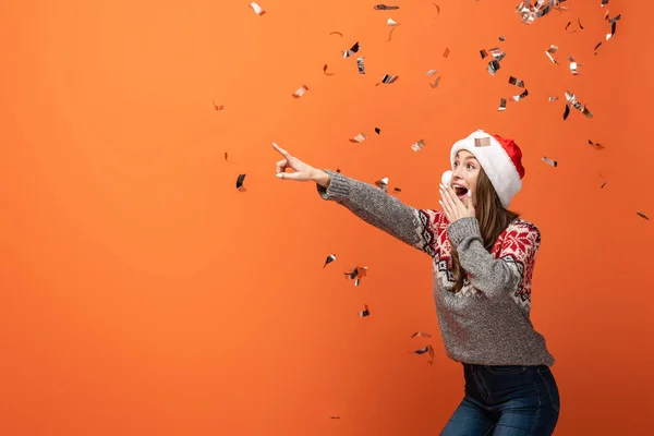 Femme Surprise Santa Chapeau Sous Les Confettis Tombant Pointant Doigt — Photo