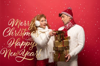Kış kıyafetli mutlu çift Noel hediyelerini kırmızıda, mutlu noeller ve mutlu yeni yıl mektupları taşıyorlar.