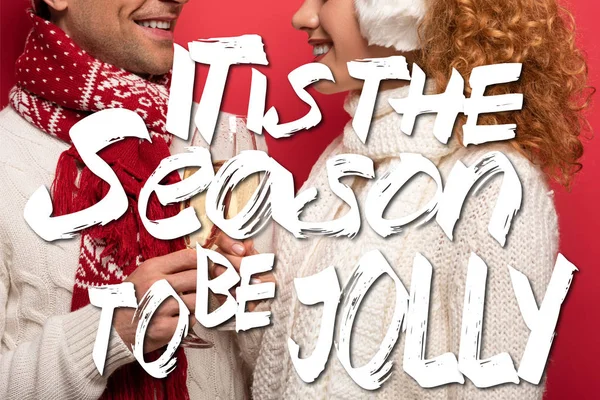 赤のシャンパングラスでクリンクする冬の衣装で笑顔のカップルのクロップドビューが楽しいイラストになる季節 — ストック写真