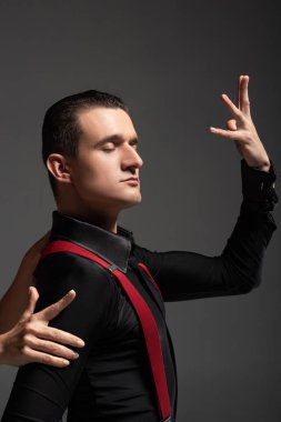 Kadın eli, şehvetli bir dansçının yanında, kapalı gözlerle gri renkte tango yaparken görüntülendi.