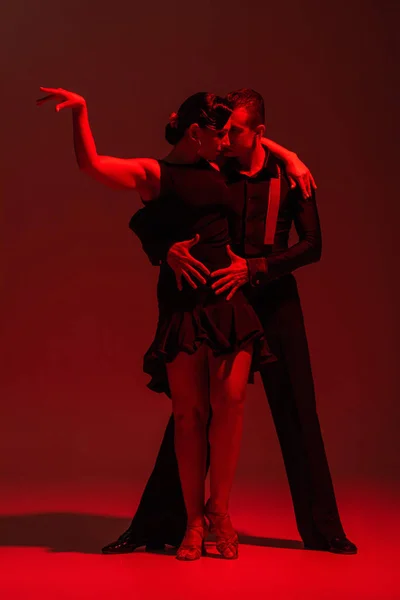 Elegante Pareja Bailarines Ropa Negra Realizando Tango Sobre Fondo Oscuro —  Fotos de Stock