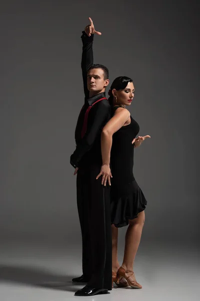 Dois Dançarinos Elegantes Roupas Pretas Realizando Tango Fundo Cinza — Fotografia de Stock