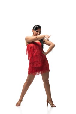 Beyaz arka planda tango yaparken parmaklarıyla işaret eden etkileyici dansçı.