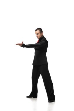 Beyaz arka planda dans etmeye davet eden zarif siyah takımlı tango dansçısı.
