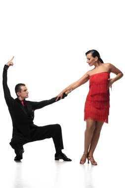 Beyaz arka planda tango yaparken güzel bir dansçının el ele tutuşması ve çömelmesi.