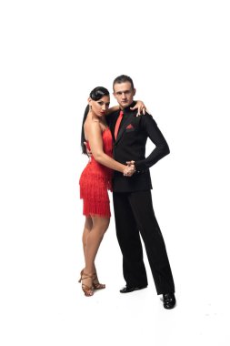 Beyaz arka planda tango yaparken kameraya bakan şık dansçılar.