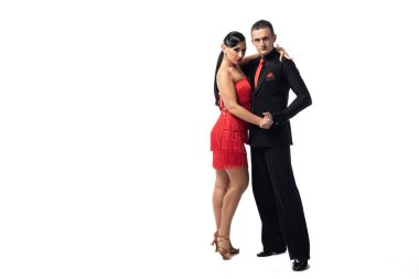 elegant couple of dancers looking at camera while performing tango on white background clipart