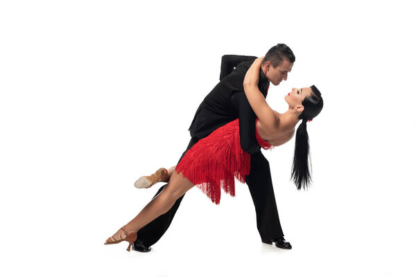 elegant dancer supporting beautiful partner while performing tango on white background