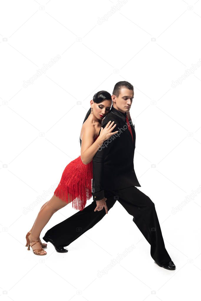 attractive dancer leaning on back of elegant partner while performing tango on white background