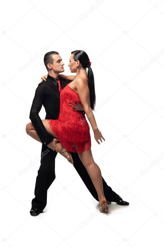 passionate, elegant couple of dancers performing tango on white background