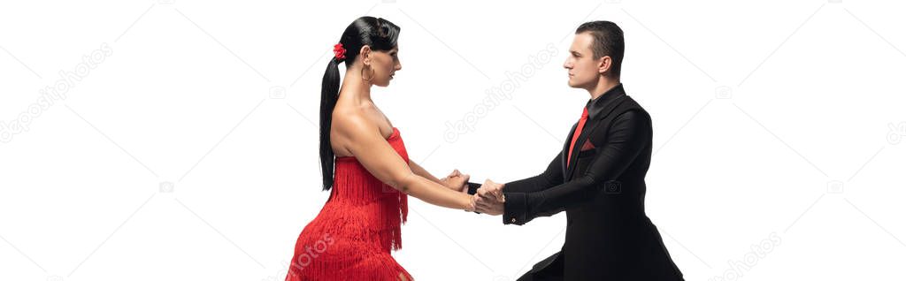 panoramic shot of passionate, elegant dancers looking at each other while performing tango isolated on white