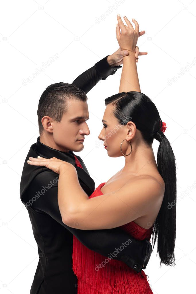 passionate dancers looking at each other while performing tango isolated on white