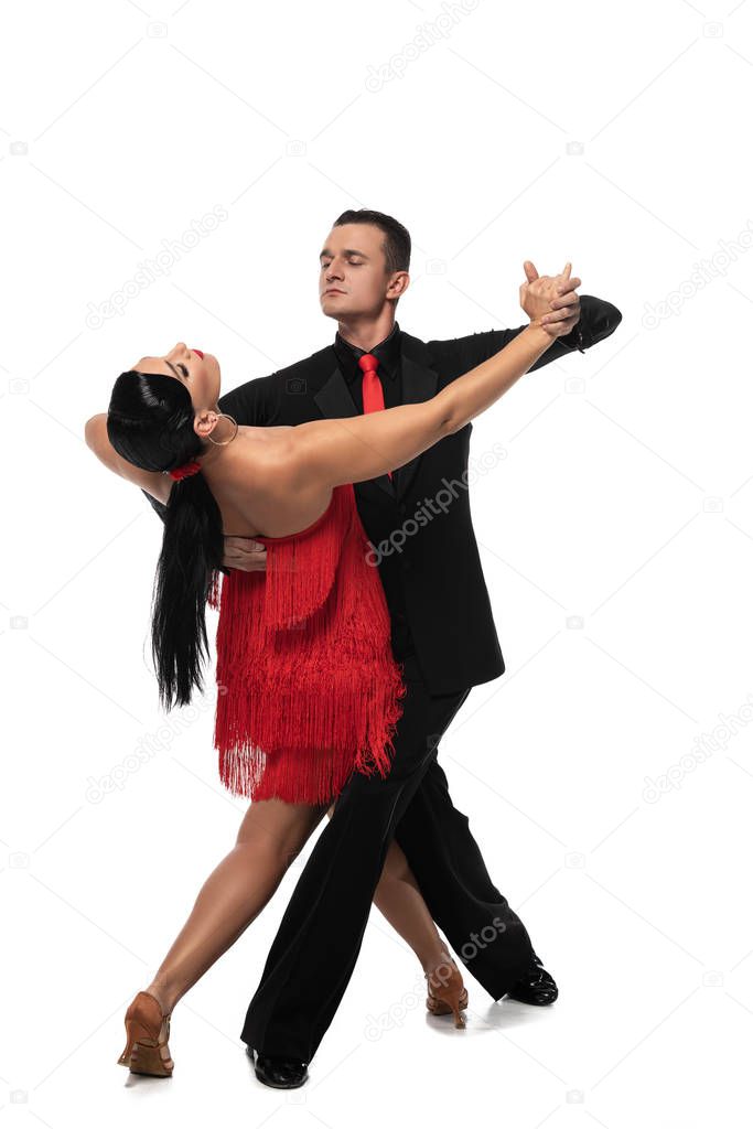 handsome, elegant dancer leading attractive partner while performing tango on white background