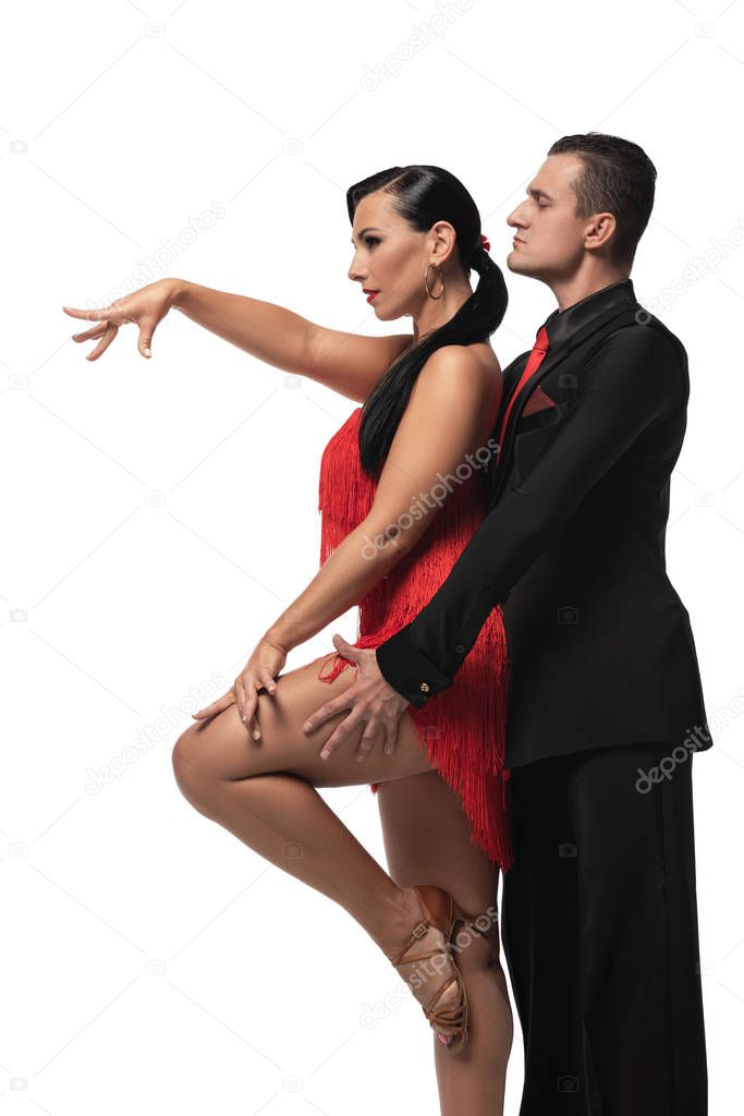 side view of expressive, elegant dancers performing tango isolated on white